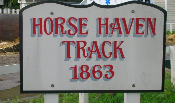 Red and gray old-timey letters on a white sign, reading "Horse Haven Track 1863"