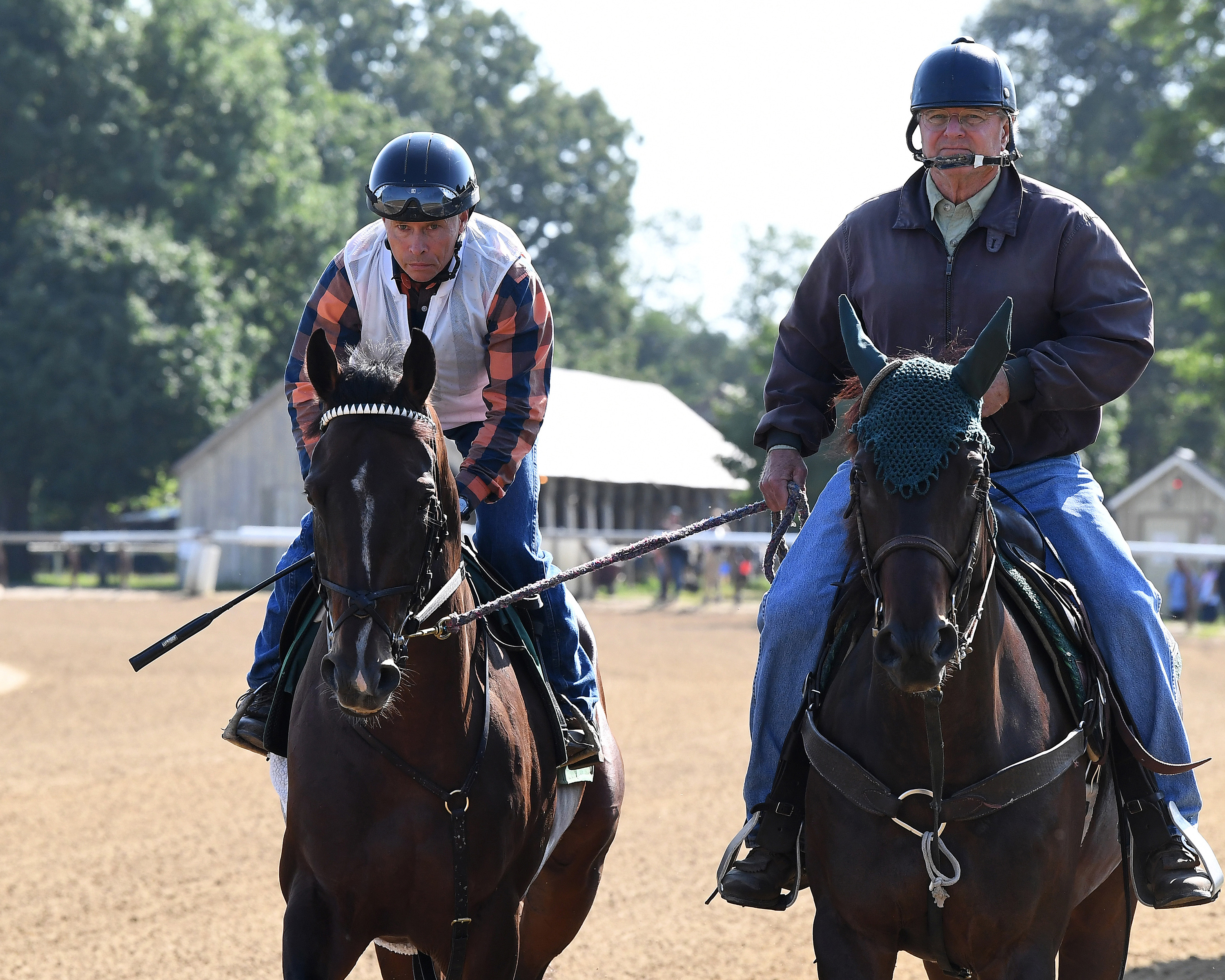 On the left, Neil Poznansky rides Sovereignty, the 2025 Kentucky Derby, Belmont, and Travers weekend. On the left is trainer Bill Mott on a pony. They are on the Oklahoma training track at Saratoga Race Course during morning training.